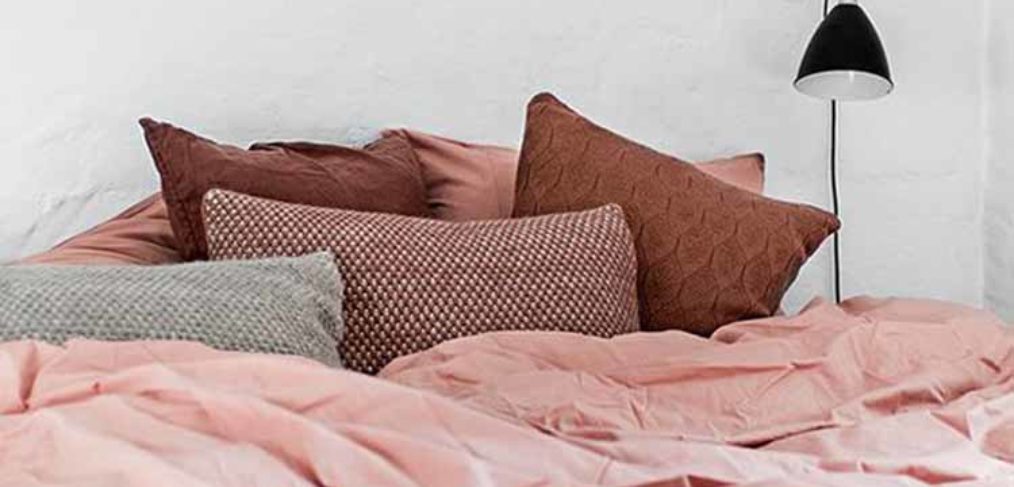Camera da letto con lenzuola rosa cipria